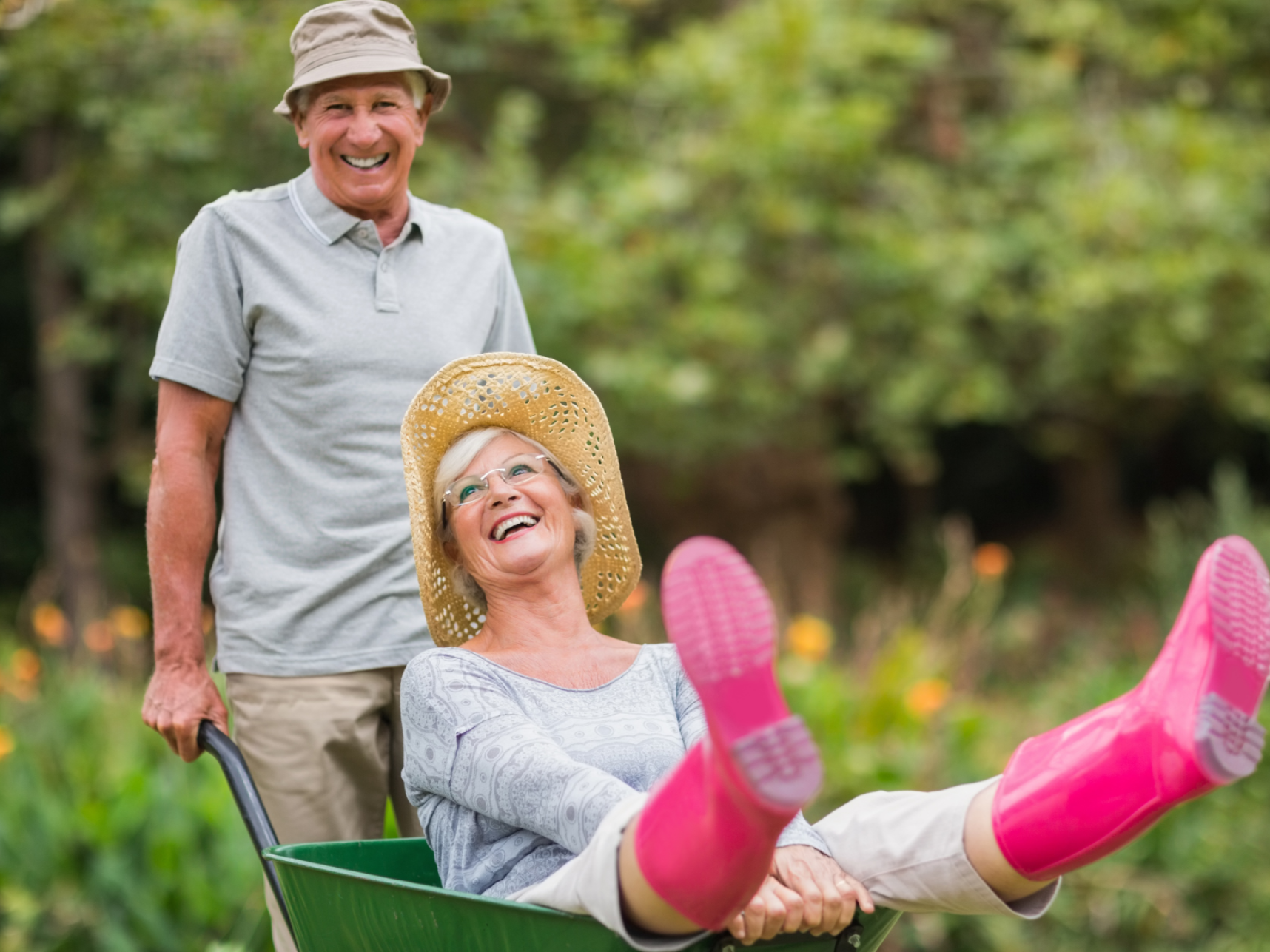 Happy senior couple playing with a wheelbarrow